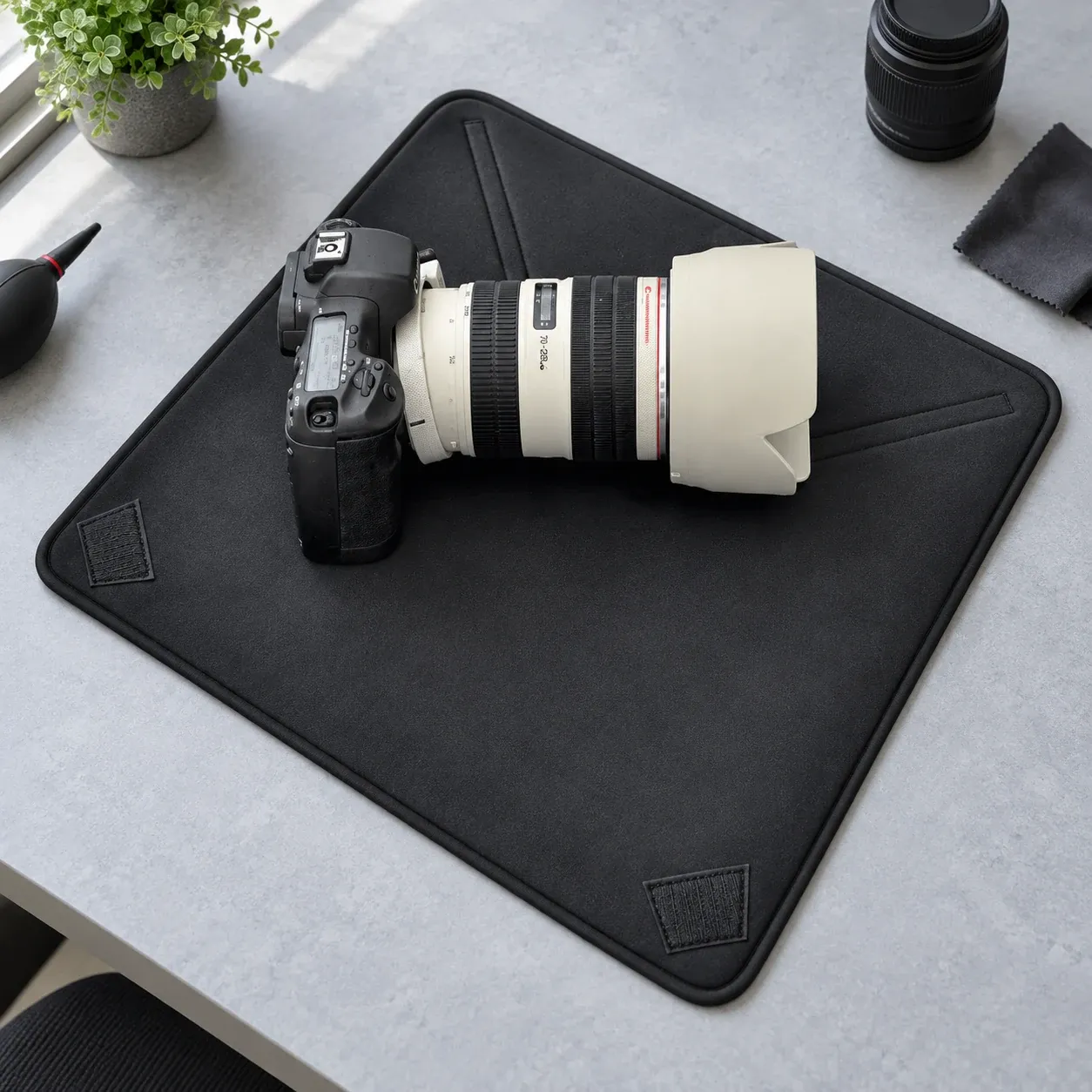 Open black wrap beneath photography equipment; camera and lenses are not included